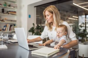 Single mother with baby working in office
